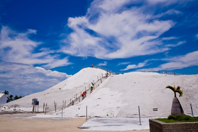 Silhouettes of people climbing up the salt mountain