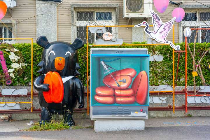 喔熊拿著以雲嘉南濱海區聞名的烏魚子站在烏魚子夾娃娃機旁