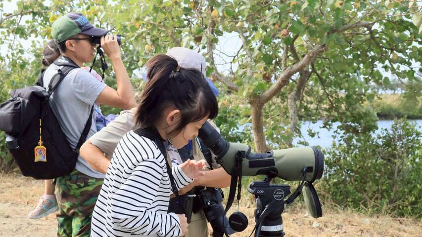小朋友透過高倍率的單筒望遠鏡（賞鳥鏡）觀察野鳥